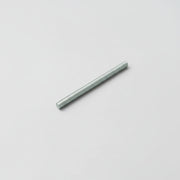Long, thin metallic rod on a light gray background